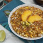 round-white-bowl-filled-with-Colorado-salsa-Palisade-peaches-Pueblo-green-chiles-and-olathe-sweet-corn-garnished-with-lime