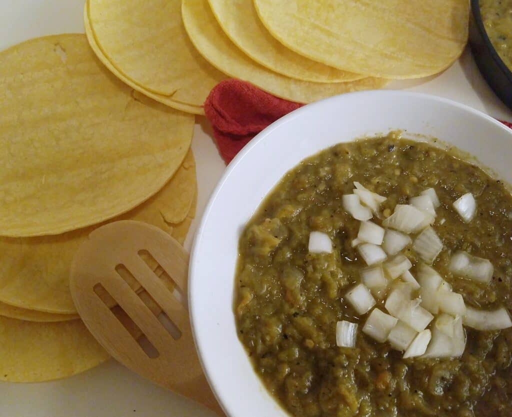 round-white-bowl-of-New-Mexican-Style-Hatch-Green-Chile-Sauce-garnished-with-onions