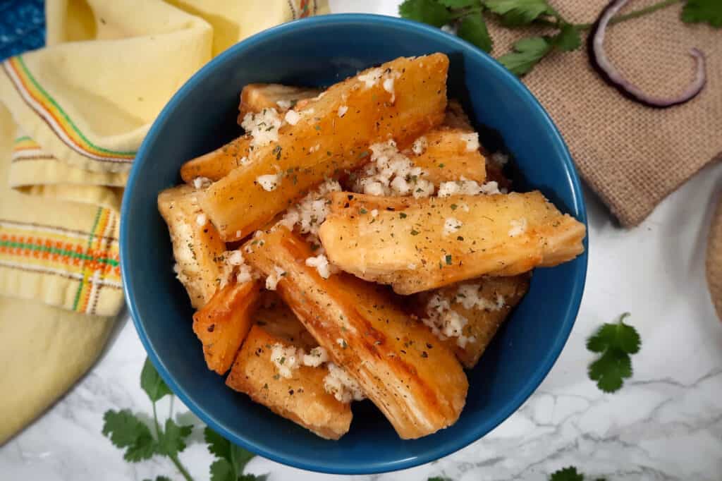 Yuca-frita-con-mojo-in-blue-bowl-with-yellow-cloth