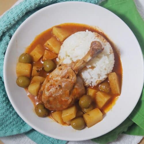 Cuban-fricase-de-pollo-single-drumstick-served-over-rice-in-white-bowl