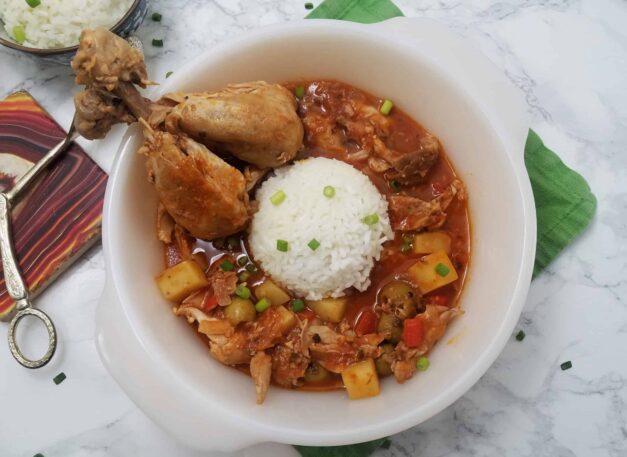 serving-dish-of-Fricasé-de-pollo-Cuban-chicken-fricassee-with-two-drumsticks-and-white-rice