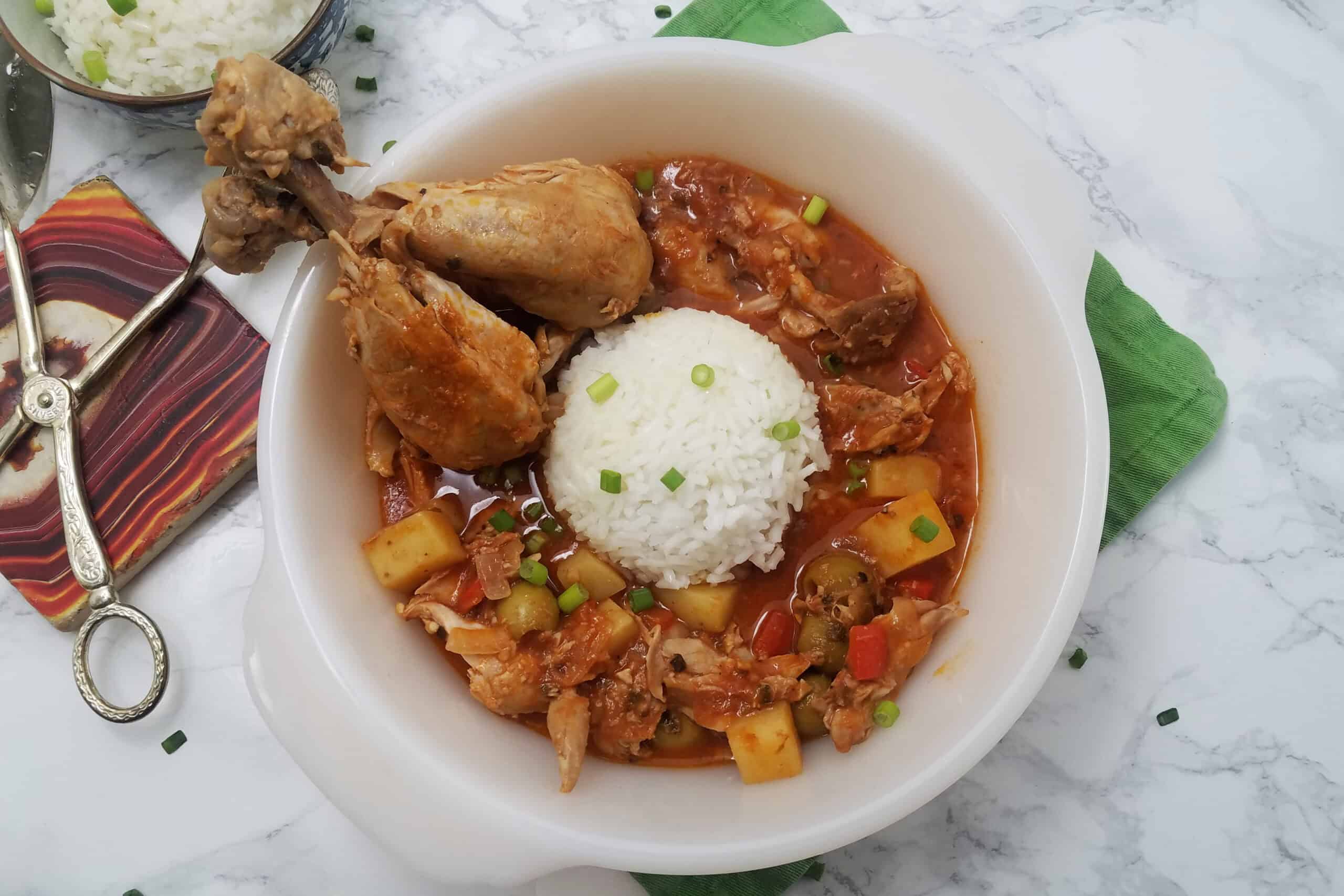 serving-dish-of-Fricasé-de-pollo-Cuban-chicken-fricassee-with-two-drumsticks-and-white-rice