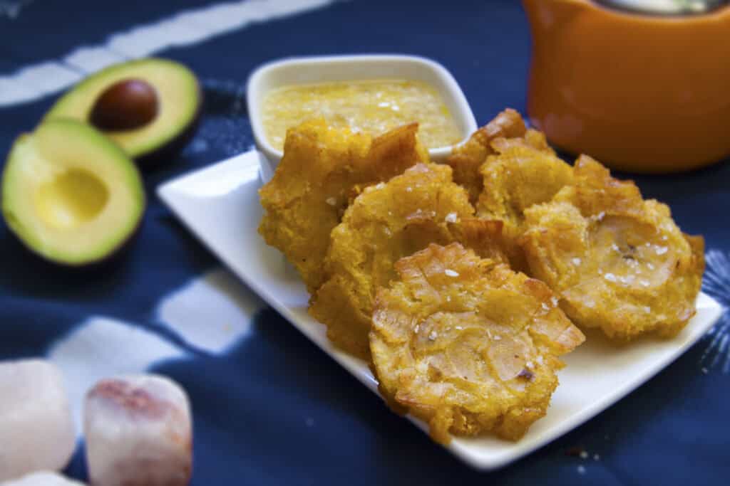 six-stacked-Cuban-tostones-con-mojo-on-white-plate-garnished-with-salt