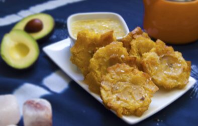 six-stacked-Cuban-tostones-con-mojo-on-white-plate-garnished-with-salt