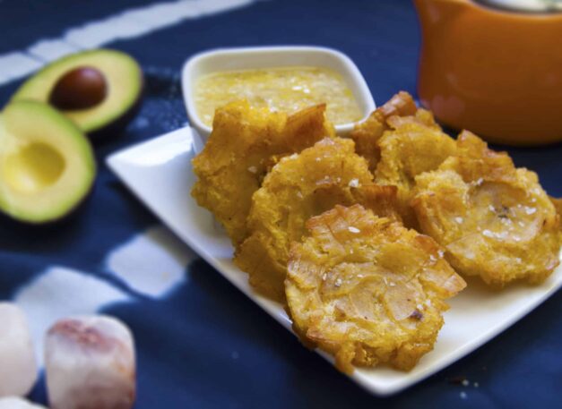 six-stacked-Cuban-tostones-con-mojo-on-white-plate-garnished-with-salt