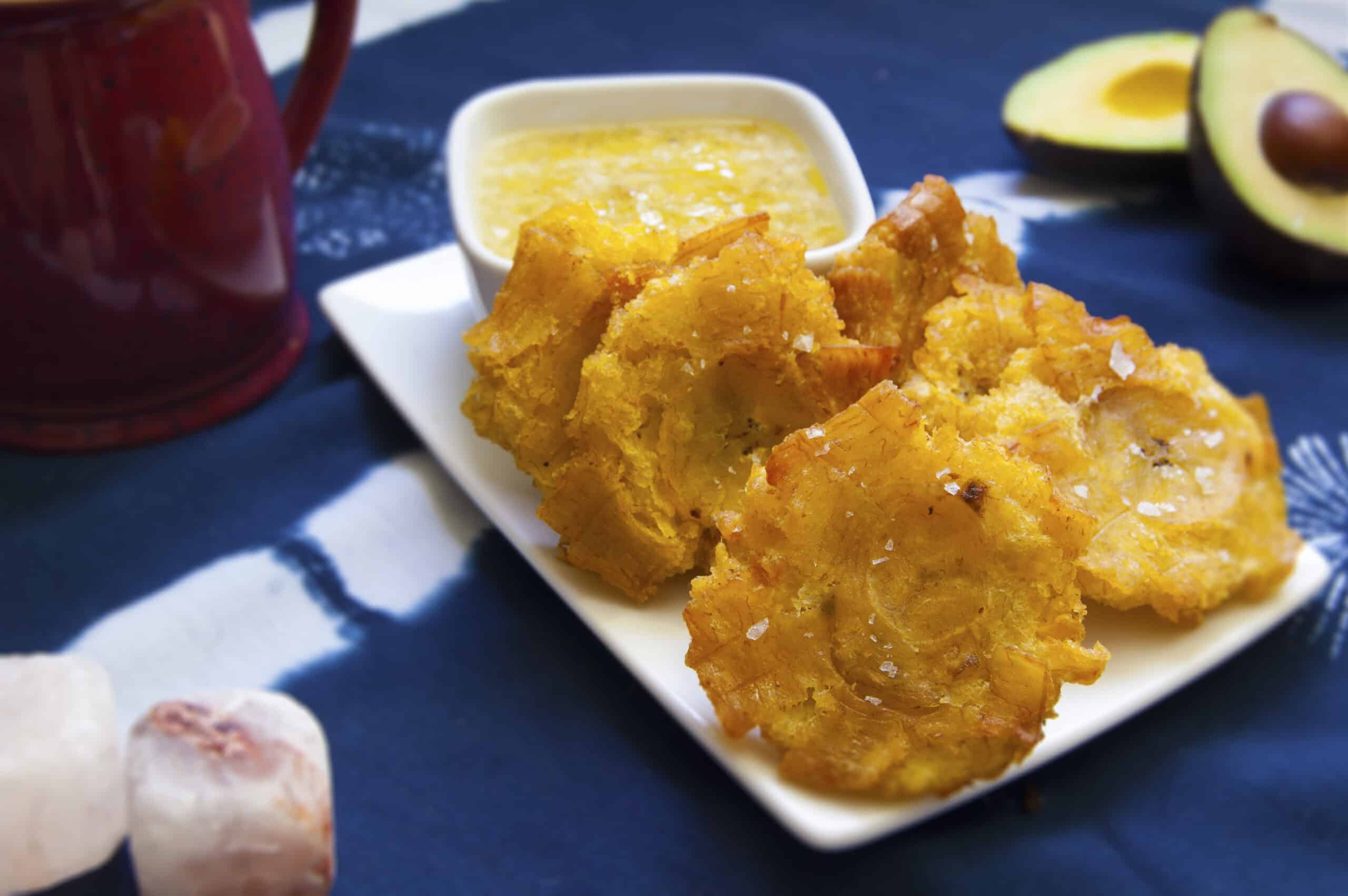 five-stacked-Cuban-tostones-con-mojo-with-salt-garnish-on-white-plate