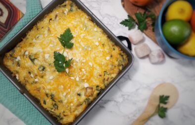 top-view-breakfast-polenta-casserole-in-baking-pan-garnished-with-crumbled-cheese-and-parsley