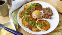 six-cheddar-scallion-sourdough-pancakes-with-miso-butter-arranged-in-semi-circle-served-with-sausage