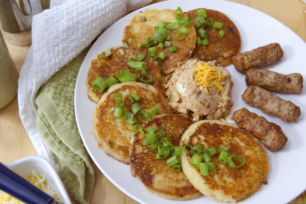 six-cheddar-scallion-sour-dough-pancakes-arranged-in-semi-circle-served-with-miso-butter-and-sausage