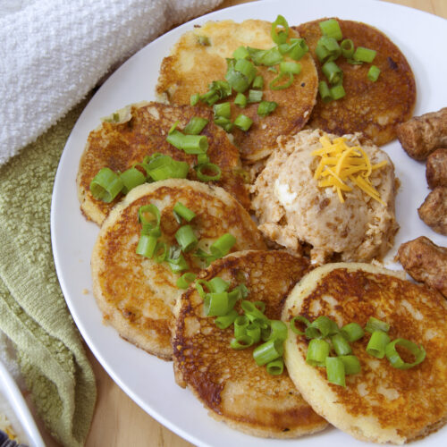 six-cheddar-scallion-sour-dough-pancakes-arranged-in-semi-circle-served-with-miso-butter-and-sausage