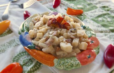 Kartoffelsalat-German-potato-salad-served-in-garden-vegetable-themed-porcelain-dish-garnished-with-bacon