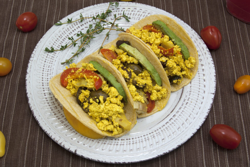 side-view-mediterranean-tofu-scramble-and-avocados-filling-three-corn-tortillas-garnished-with-thyme