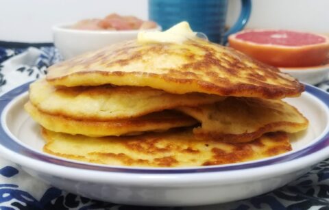 side-view-four-stacked-potato-pancakes-topped-with-melted-butter