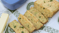 cascading-slices-broccoli-cheddar-bread-on-white-green-paisley-tablecloth-garnished-with-green-onions