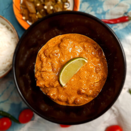 top-view-jain-vegetarian-rajma-garnished-with-lime-wedge-served-in-brown-bowl