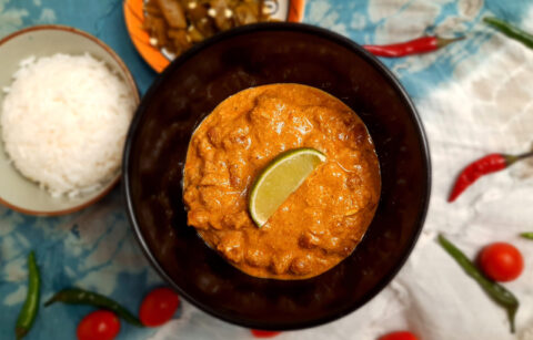 top-view-jain-vegetarian-rajma-garnished-with-lime-wedge-served-in-brown-bowl