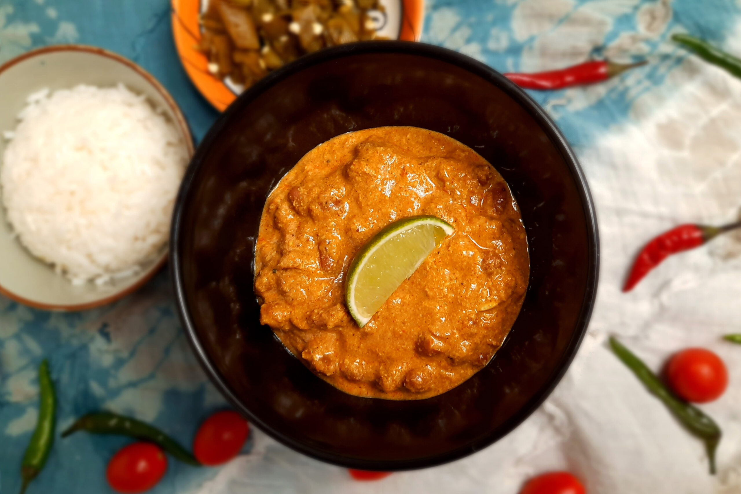 top-view-jain-vegetarian-rajma-garnished-with-lime-wedge-served-in-brown-bowl