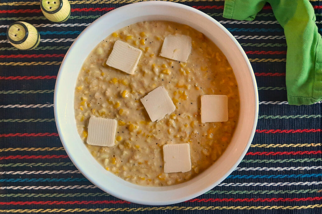 Swedish-corn-pudding-before-baking-with-pats-of-butter-in-round-ceramic-dish