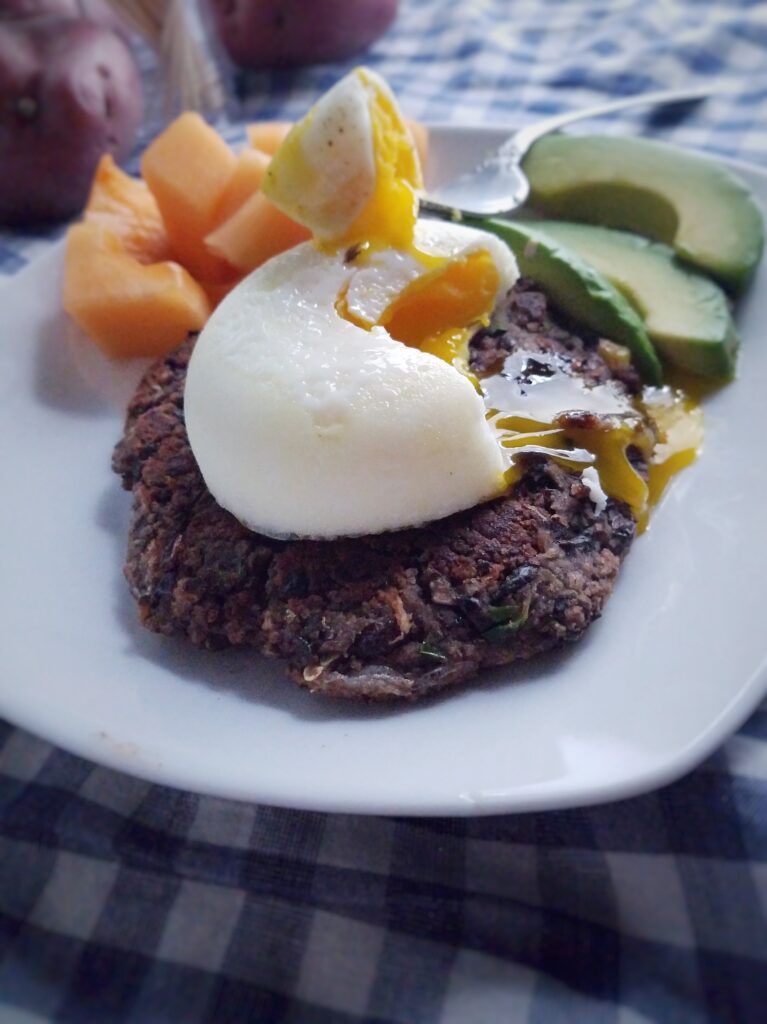 black-bean-patty-topped-with-egg-served-for-breakfast-with-fruit