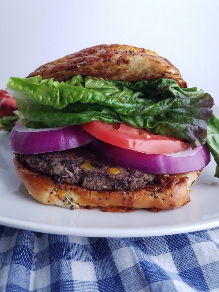 black-bean-patties-served-in-a-bun-with-lettuce-tomatoes-and-red-onion