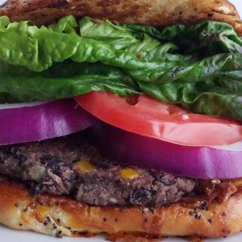 Ultimate-veggie-burger-best-black-bean-patties-served-on-bun-with-lettuce-tomatoes-and-onion