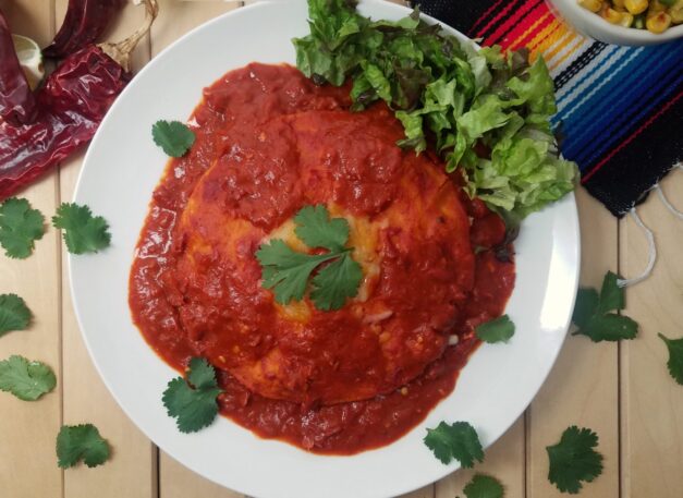 New-Mexican-style-stacked-enchiladas-with-red-sauce-on-white-plate-garnished-with-cilantro