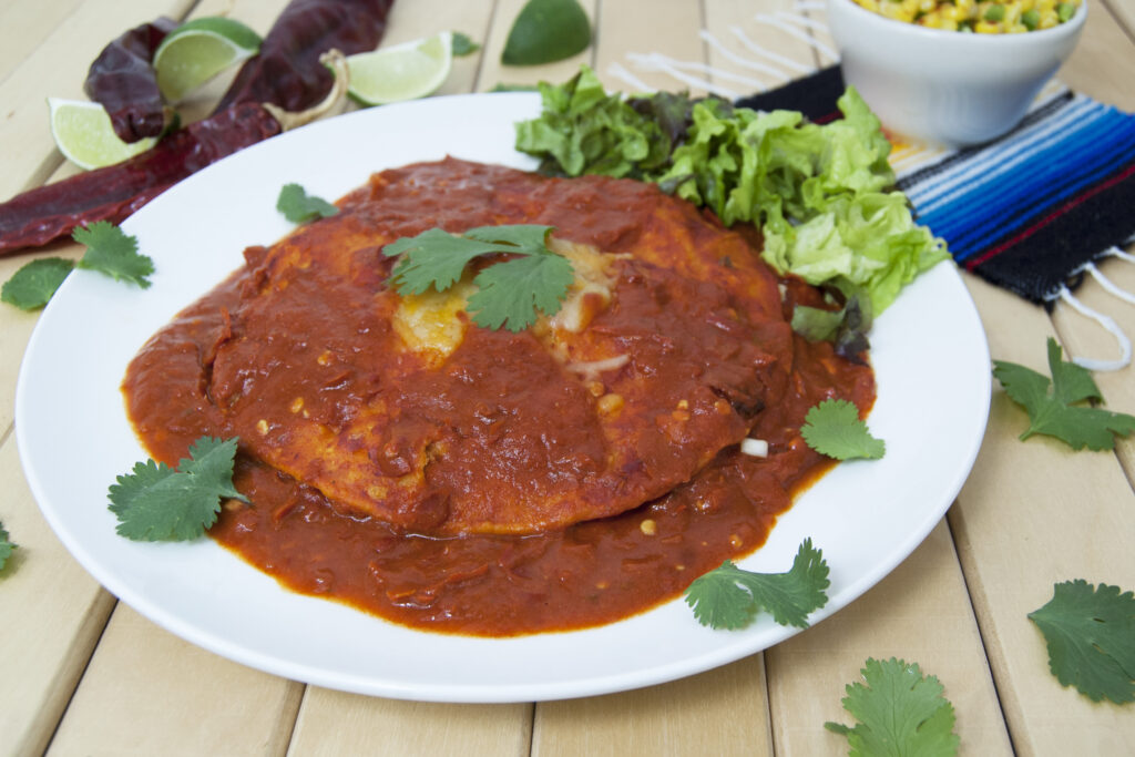 side-view-New-Mexican-style-stacked-enchiladas-garnished-with-lettuce-and-cilantro