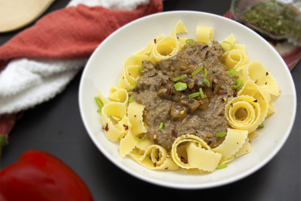 ultra-umami-mushroom-sauce-served-over-egg-noodles-in-white-bowl