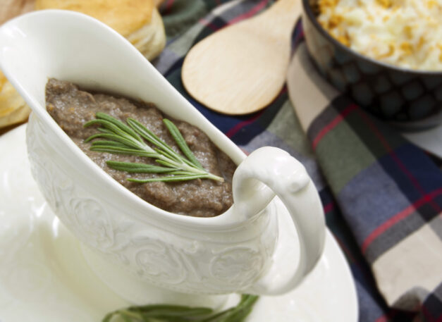 white-dish-with-ultra-umami-thick-mushroom-gravy-garnished-with-rosemary-served-with-biscuits