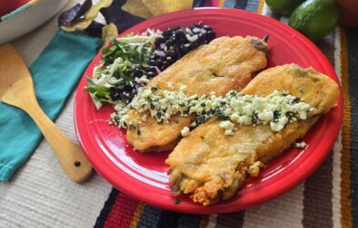 New-Mexican-style-chiles-rellenos-made-with-Hatch-chile-peppers-served-with-side-of-beans