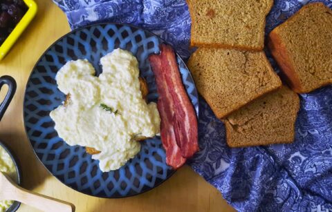 top-view-Swedish-egg-gravy-on-rye-bread-served-with-bacon-on-blue-plate