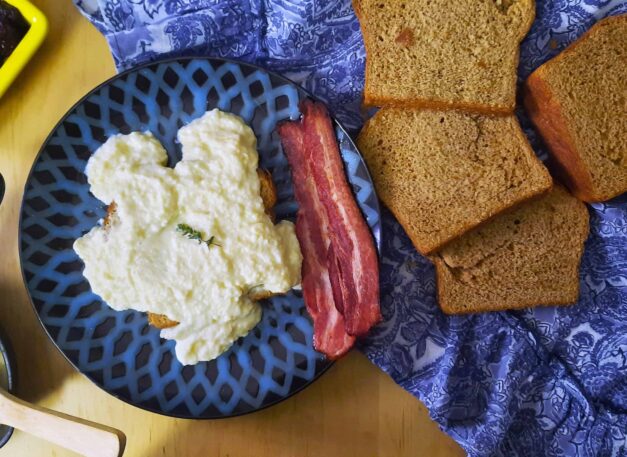 top-view-Swedish-egg-gravy-on-rye-bread-served-with-bacon-on-blue-plate