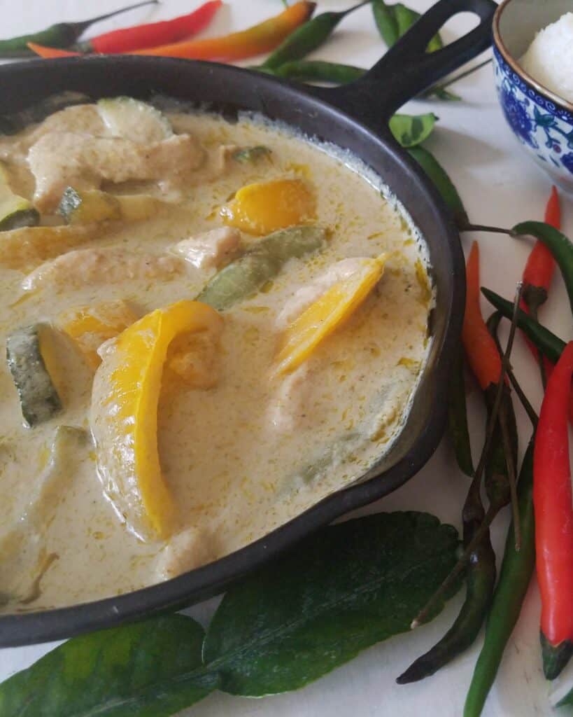 restaurant-style-thai-green-curry-in-cast-iron-pan-surrounded-by-birds-eye-chiles
